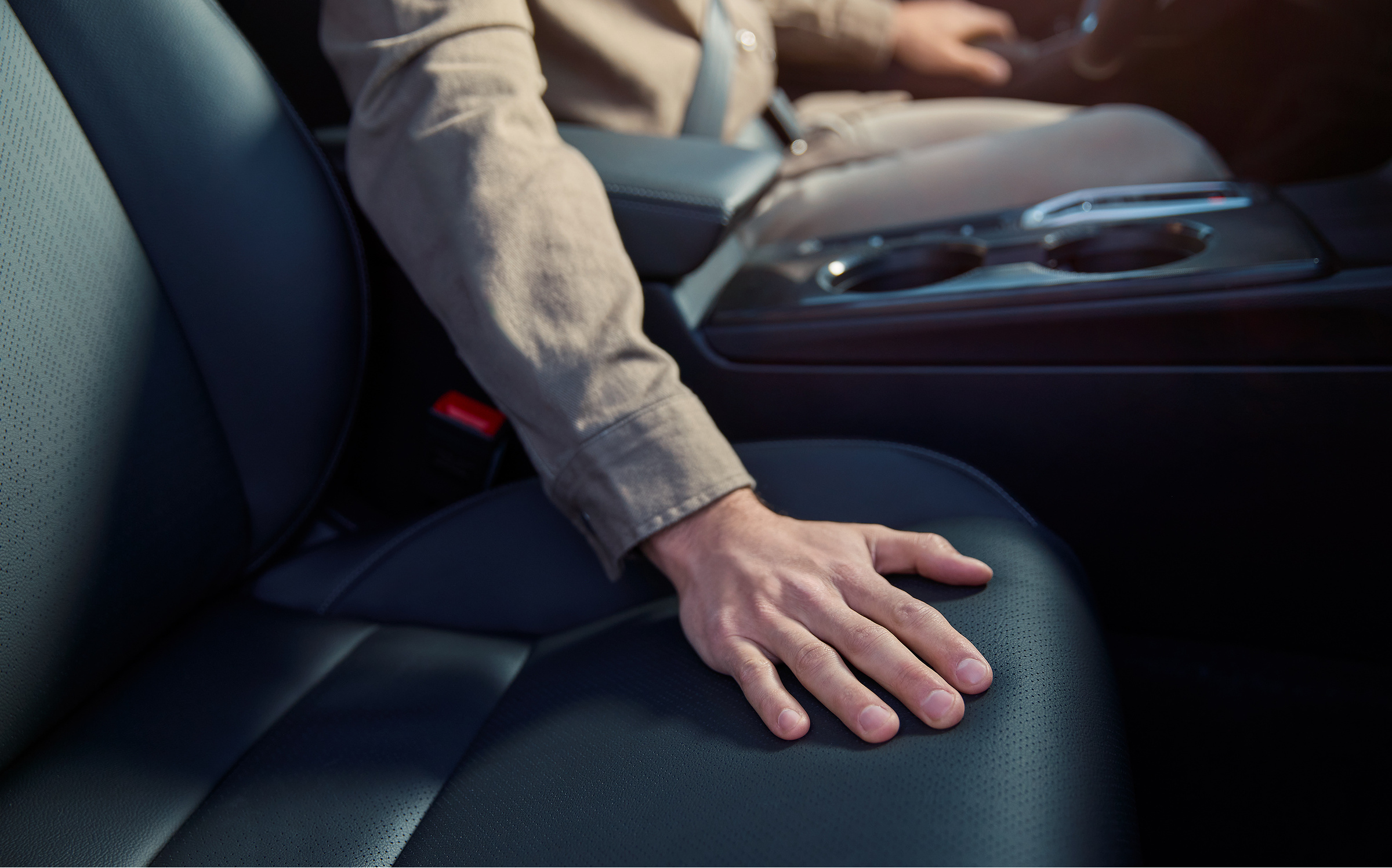 A Honda Civic Hybrid belsejében lévő ülésekhez érő személy.